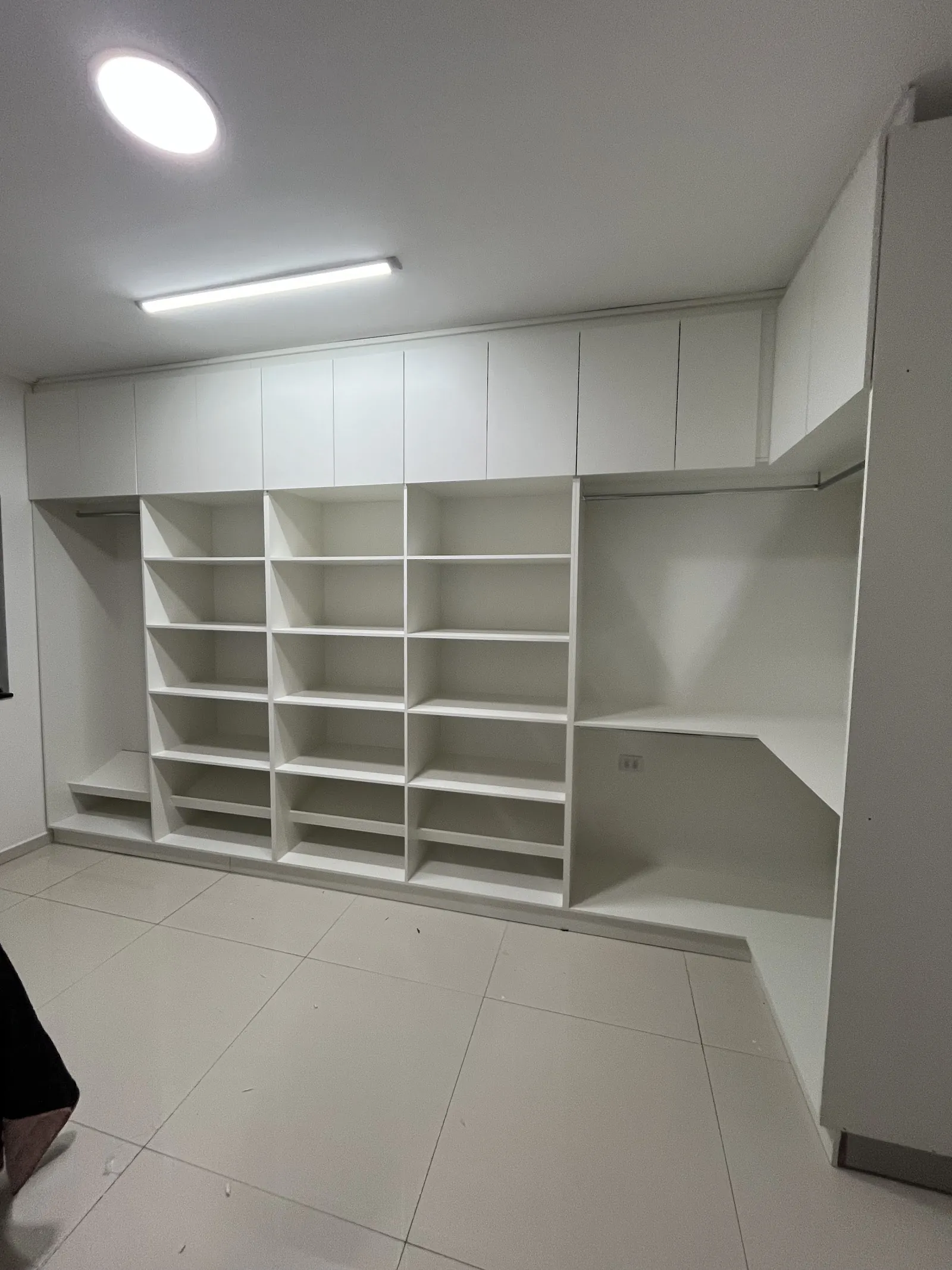 Closet planejado branco com nichos, prateleiras e maleiro