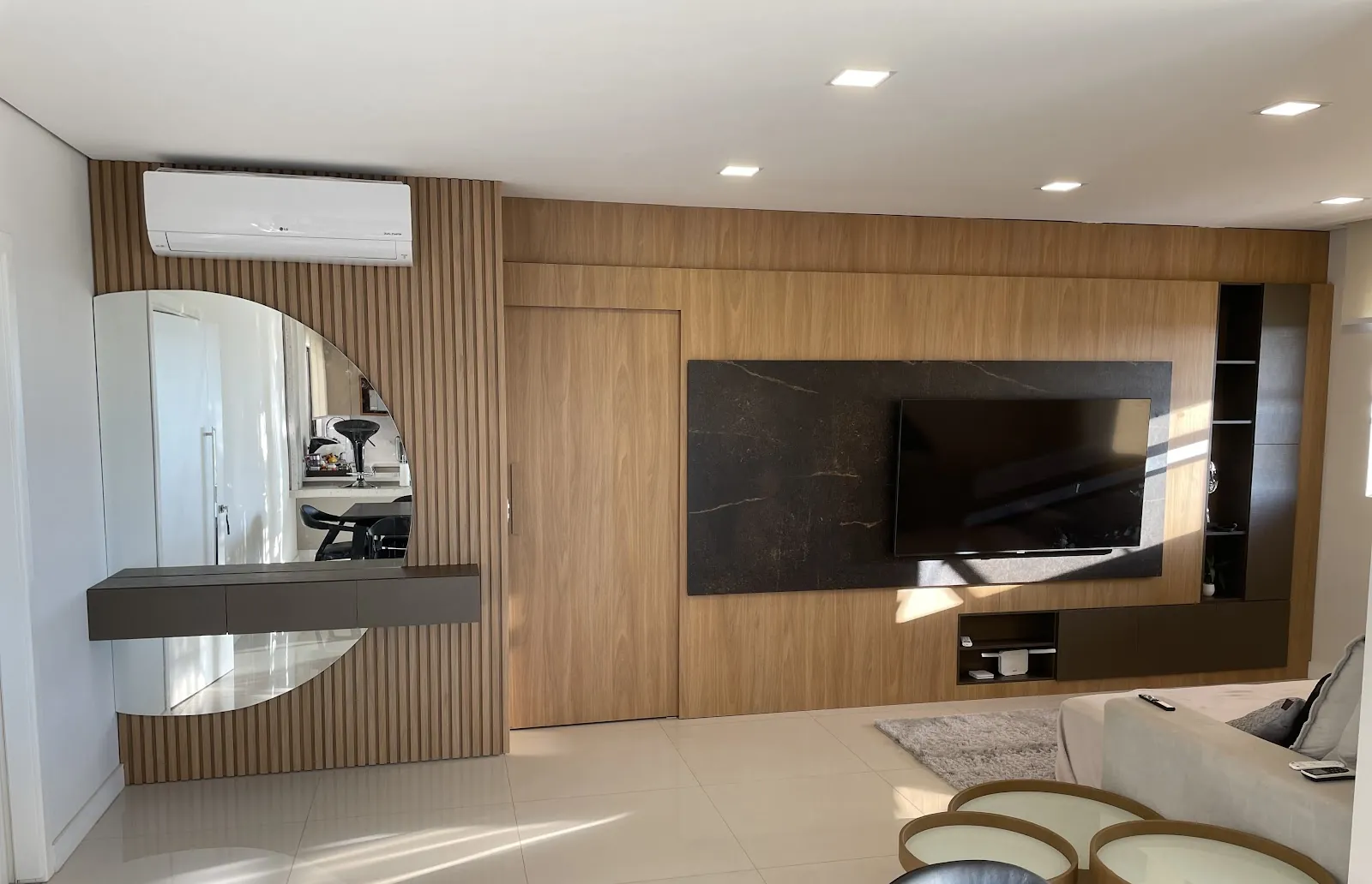 Sala com painel de TV em madeira, ripado e aparador com espelho feitos pela Casola Marcenaria em Foz do Iguaçu